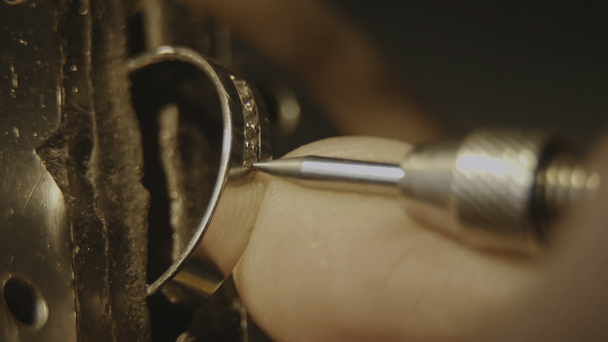 The jeweller is setting a precious stone. Craft jewelery making. Ring repairing. Putting the diamond